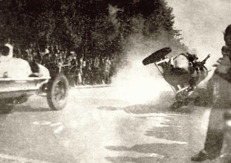 A black-and-white photograph capturing the moment Hellé Nice's Alfa Romeo flips mid-air into the trackside crowd during the final lap of the São Paulo Grand Prix on July 12, 1936. Another race car passes on the left, while spectators and dust surround the airborne vehicle on the Jardim América street circuit.